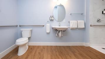 A bathroom with a toilet, sink, and shower.