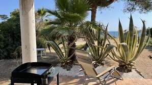 A patio area with a grill, a folding chair, and large agave plants. - Villa for 8 people on the Gigaro beach (La Croix-Valmer)
