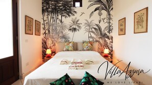 A hotel room with a bed, two nightstands, a window, and a tropical mural on the wall. - Villa Azzura Lipari - Charm & Relax (Lipari)
