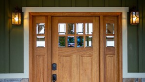 A wooden front door with a glass panel, a doormat, and two potted plants. - Luxury Lodge with Ride-In-Ride-Out Location - WiFi - Sweeping Mountain Views (Huntsville)