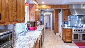A modern kitchen with wooden cabinets, stainless steel appliances, and a marble countertop. - Charming estate on Norwich Green, near casinos (Norwich)