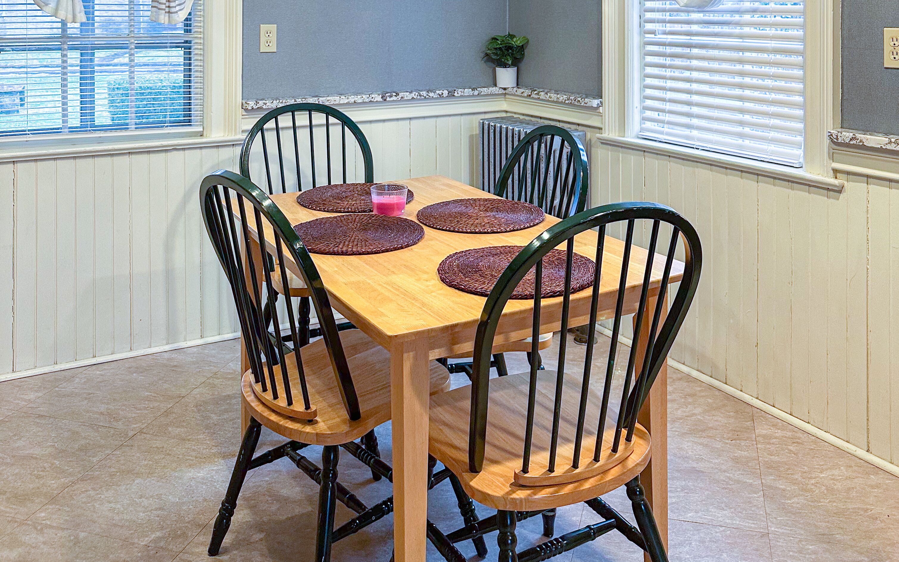 Una mesa de comedor con cuatro sillas, cada una con un mantel tejido.