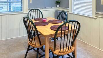 Una mesa de comedor con cuatro sillas, cada una con un mantel tejido.