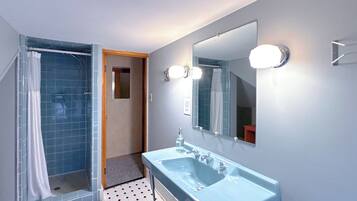 A bathroom with a shower, a sink, and a mirror.