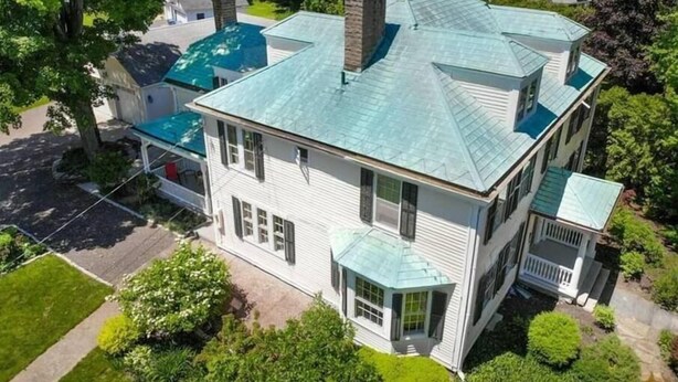 A large, two-story house with a prominent chimney, a covered porch, and a well-maintained lawn. - Charming estate on Norwich Green, near casinos (Norwich)