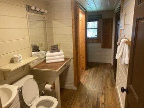 Une salle de bain avec des toilettes, un lavabo et des serviettes pliées.