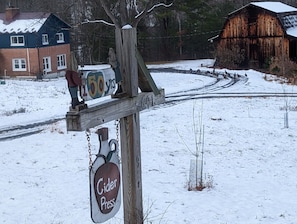 A wooden signpost with a cider press sign and a '150 years' plaque.