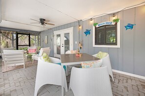 Relax in this inviting patio area with a wooden table and comfortable wicker chairs.