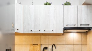Une cuisine moderne avec des meubles en bois, un réfrigérateur en acier inoxydable et un four encastré.
