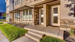 A multi-story building with stone facade, large windows, and a covered entryway. - Old Town Swank - Brand New To Brewery District! (Fort Collins)