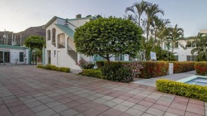 A spacious courtyard with a reception area, a staircase, and a pool. - Hotel Parotas Manzanillo (Manzanillo)