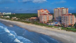 A beachfront hotel with multiple high-rise buildings, a sandy beach, and ocean waves. - Marriott's OceanWatch Two Bedroom Beachfront Resort (Myrtle Beach)
