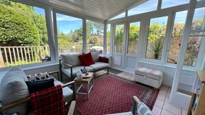A covered patio with a sofa, chairs, and a small table. - Cosy traditional cottage with parking and garden (Ryde)