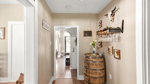 A hallway with a wooden barrel, wine glasses on a rack, and a sign reading "Bourbon Street". - Welcome to the Rusty Rose-Restored Farmhouse feel in the heart of Jefferson, MD (Jefferson)