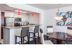 Enjoy meals in the kitchen and dining area, featuring a round table and stainless steel appliances.