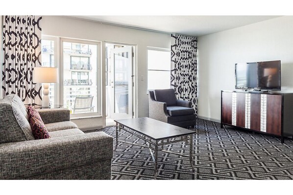 Relax in a stylish room with a comfortable sofa, armchair, and flat-screen TV.