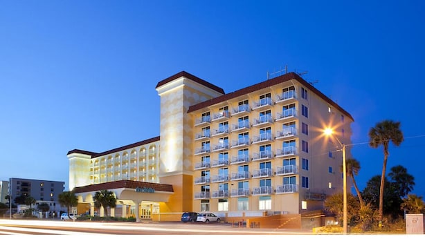 A multi-story hotel with a central tower, balconies, and a well-lit entrance. - CASA DEL MAR BEACH RESORT (Ormond Beach)