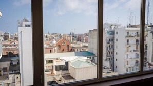 A view from a window overlooking a cityscape with buildings, including a church with a clock tower. - Dolci Emozioni Room 82 (Bari)