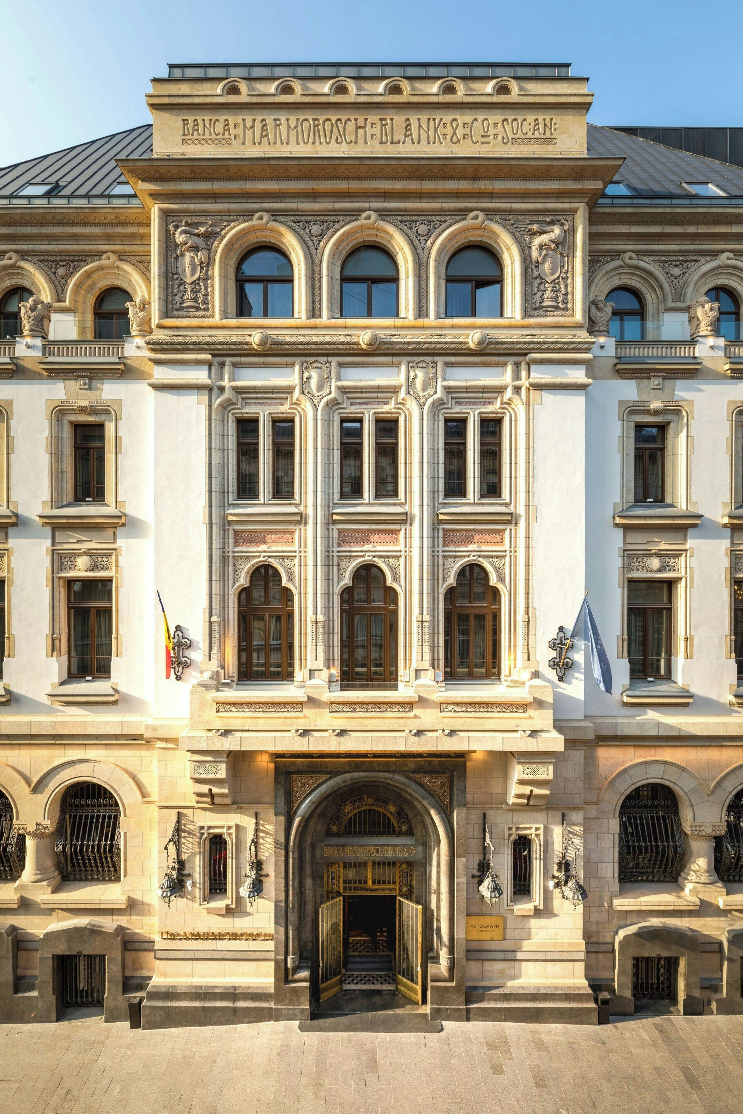 Un edificio histórico con arquitectura ornamentada, que presenta una entrada imponente, múltiples ventanas y detalles decorativos.