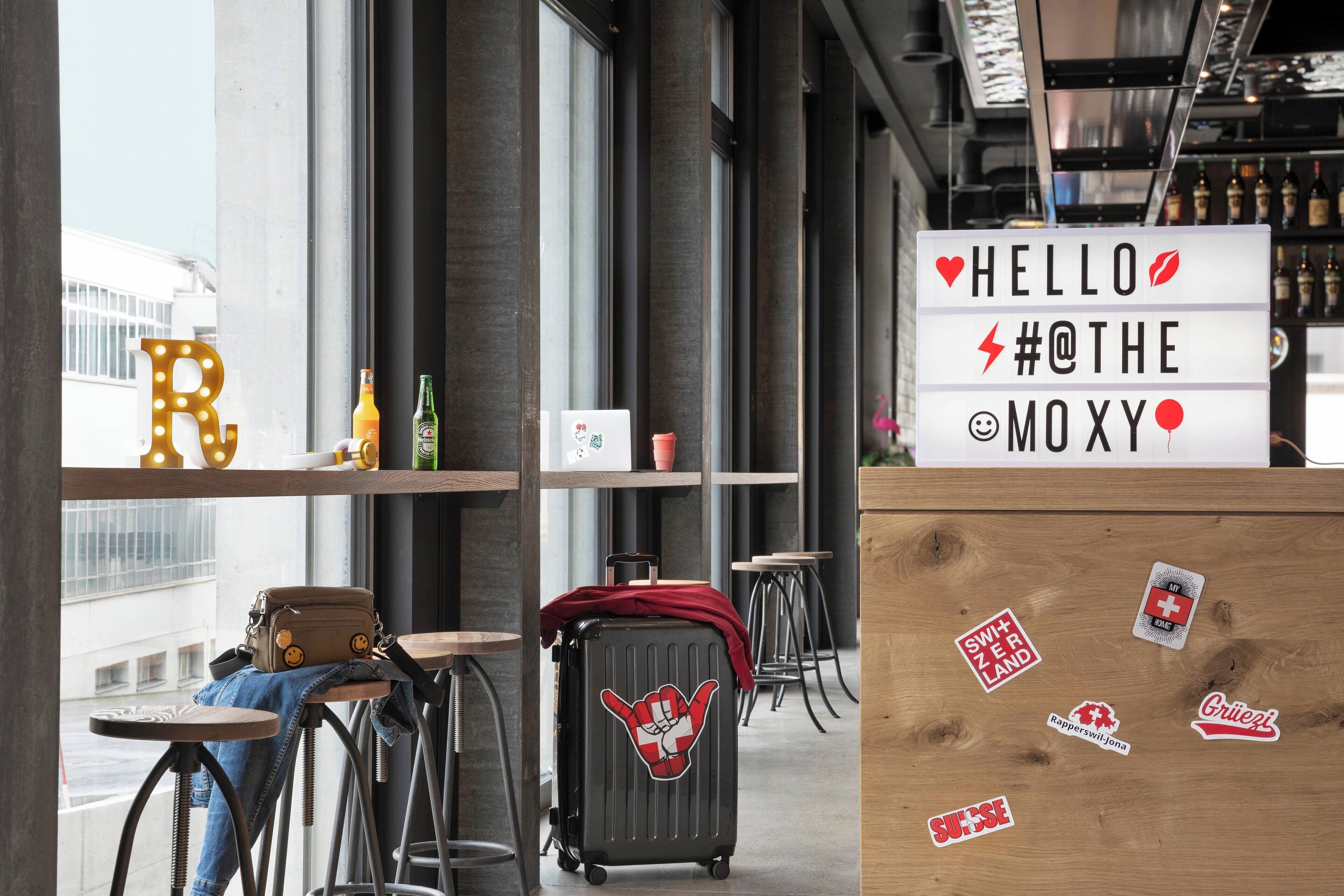 Eine moderne Bar mit einer Theke, Barhocker und einem Koffer mit Aufklebern.