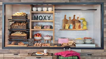 A bakery display with various baked goods and a sign that reads "MOXY".
