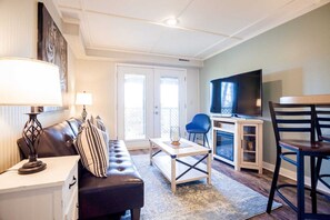 A living room with a sofa, coffee table, TV, and chairs.