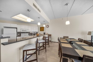 Enjoy meals and gatherings in this kitchen and dining area with an oven, stainless steel appliances, and a spacious island with bar stools.
