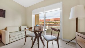 A room with a sofa, two chairs, a table with a basket, and a lamp.