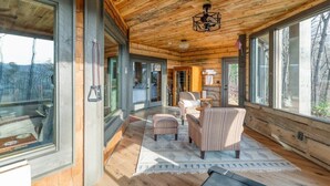 A log cabin interior with a dining area, a fireplace, and large windows. - The Secret of Blue Ridge, SHHHH don't tell anyone! (Cherry Log)