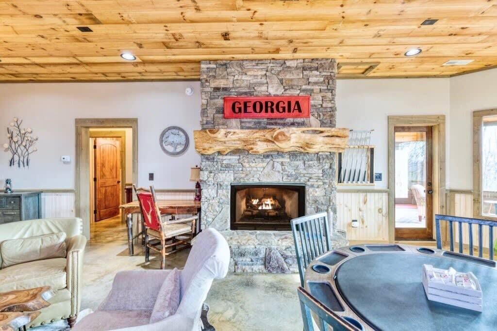 A cozy living room with a stone fireplace, a wooden ceiling, and a sign that reads "GEORGIA".