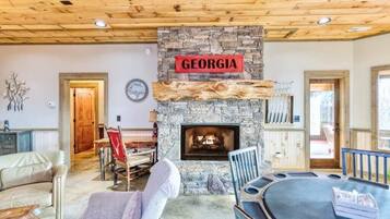 A cozy living room with a stone fireplace, a wooden ceiling, and a sign that reads "GEORGIA".