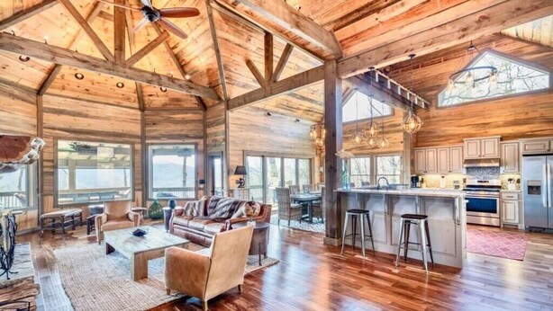 A spacious interior with a high ceiling, wooden beams, a large dining area, and a kitchen with modern appliances. - The Secret of Blue Ridge, SHHHH don't tell anyone! (Cherry Log)