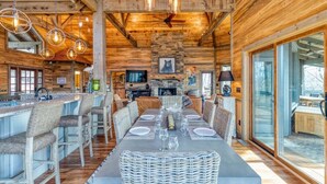 A wooden cabin interior with a dining area, bar, and fireplace. - The Secret of Blue Ridge, SHHHH don't tell anyone! (Cherry Log)