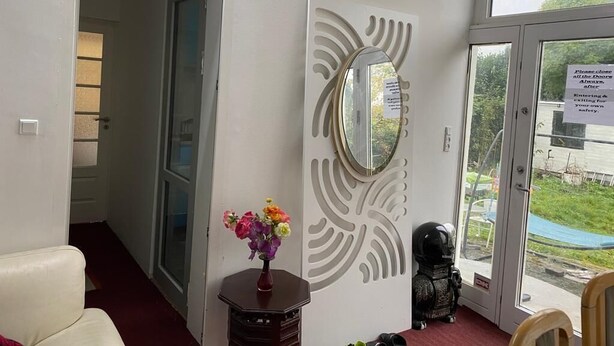 A room with a white door, a mirror, a vase with flowers, and a view of the outdoors. - Luxurious room nearby Copenhagen central (Rødovre)