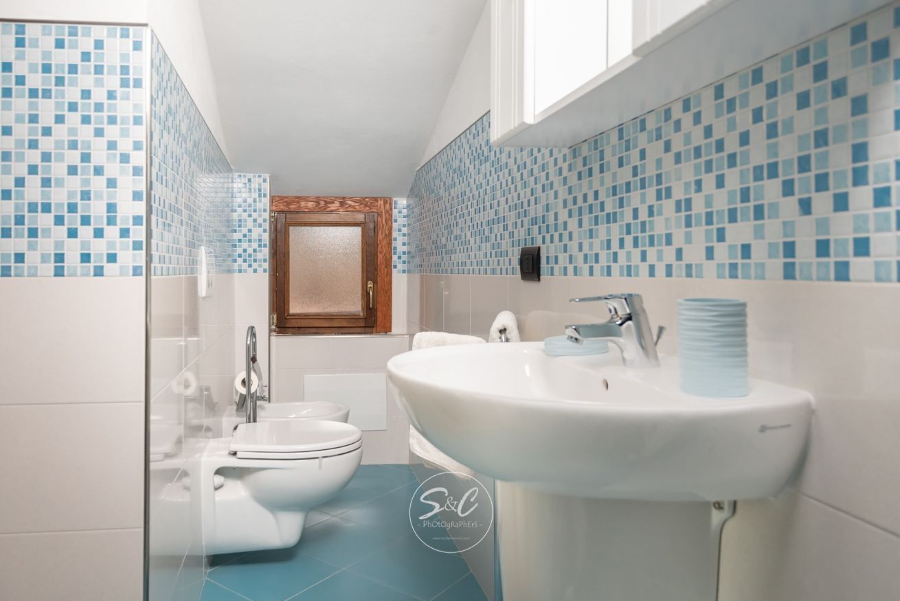 A bathroom with a toilet, sink, and shower.