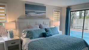 A bedroom with a bed, nightstands, a painting, and a view through a window. - Cape Gem in New Seabury resort & near the beach. (Mashpee)