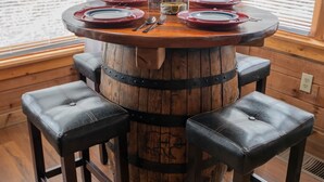 A wooden barrel table with four stools, a 'Guest Book' sign, and a fire extinguisher on the wall. - Bear Necessities: peaceful, With/romantic hot tub. (Sevierville)