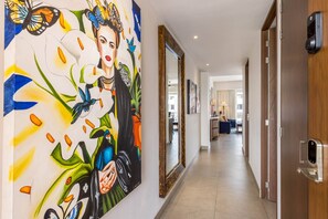 Enter through a bright hallway adorned with vibrant artwork that leads you into your stylish retreat. The thoughtfully designed entryway sets a welcoming tone for your stay.