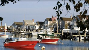 A marina with several boats docked, surrounded by residential buildings with a dock extending into the water.