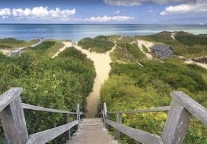 Stroll down to the beach from this charming staircase, surrounded by lush greenery and a picturesque view.