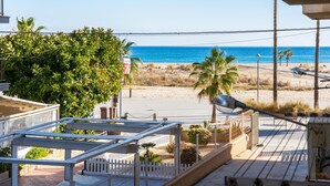 A balcony with a view of the beach and ocean.