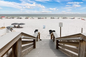A wooden staircase leading down to a sandy beach with umbrellas and beach chairs. - Bella Riva #209 Top-Tier Gated Luxury Beach Condo w/ Balcony Grill (Fort Walton Beach)