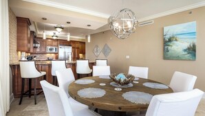 A dining area with a round table, white chairs, and a decorative centerpiece.