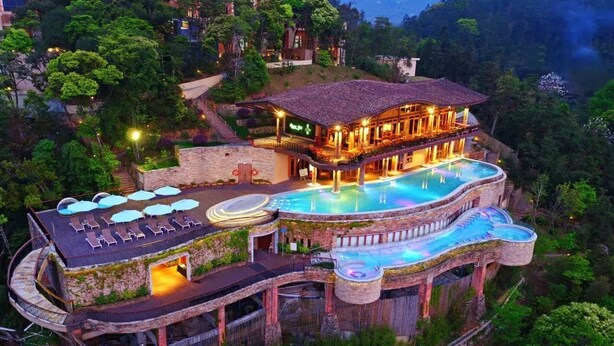 A luxurious resort with a large infinity pool, multiple levels, and outdoor seating areas. - Crosswaters Ecolodge & Spa (Huizhou)