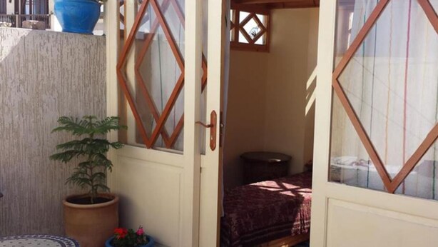 A room with a bed, a small table, and a potted plant. - We look forward to welcoming you to our home (Essaouira)