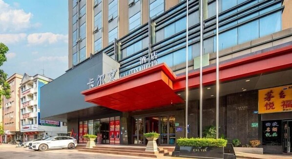 Un hotel amb una façana moderna, que destaca per un avantbosc vermell i un rètol amb caràcters xinesos.