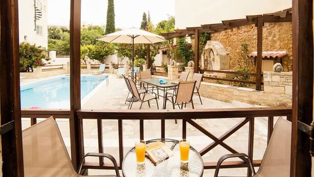 A patio area with a pool, outdoor seating, and a view of the pool. - Rousospiti Two Level Villa (Rethymno)