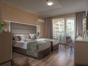 Ein Hotelzimmer mit einem großen Bett, einem Schreibtisch und einem Sessel.