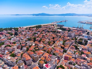 An aerial view of a coastal city with dense urban buildings, a port with cranes, and a beach in the background. - Marina Sands Bijou Boutique is an Excell (Nessebar)