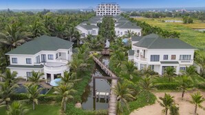 A resort with multiple white buildings, a central water feature, and surrounding greenery. - Le Palmier Ho Tram Resort (Ho Chi Minh City)